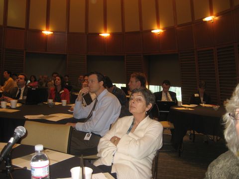 a group of people sitting at tables in a conference room