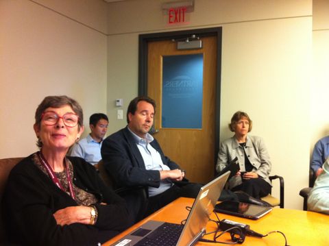 a group of people sitting at a table with laptops