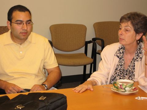 a man and woman sitting at a table with a plate of food