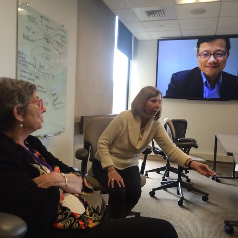 a group of people sitting in office chairs in front of a television